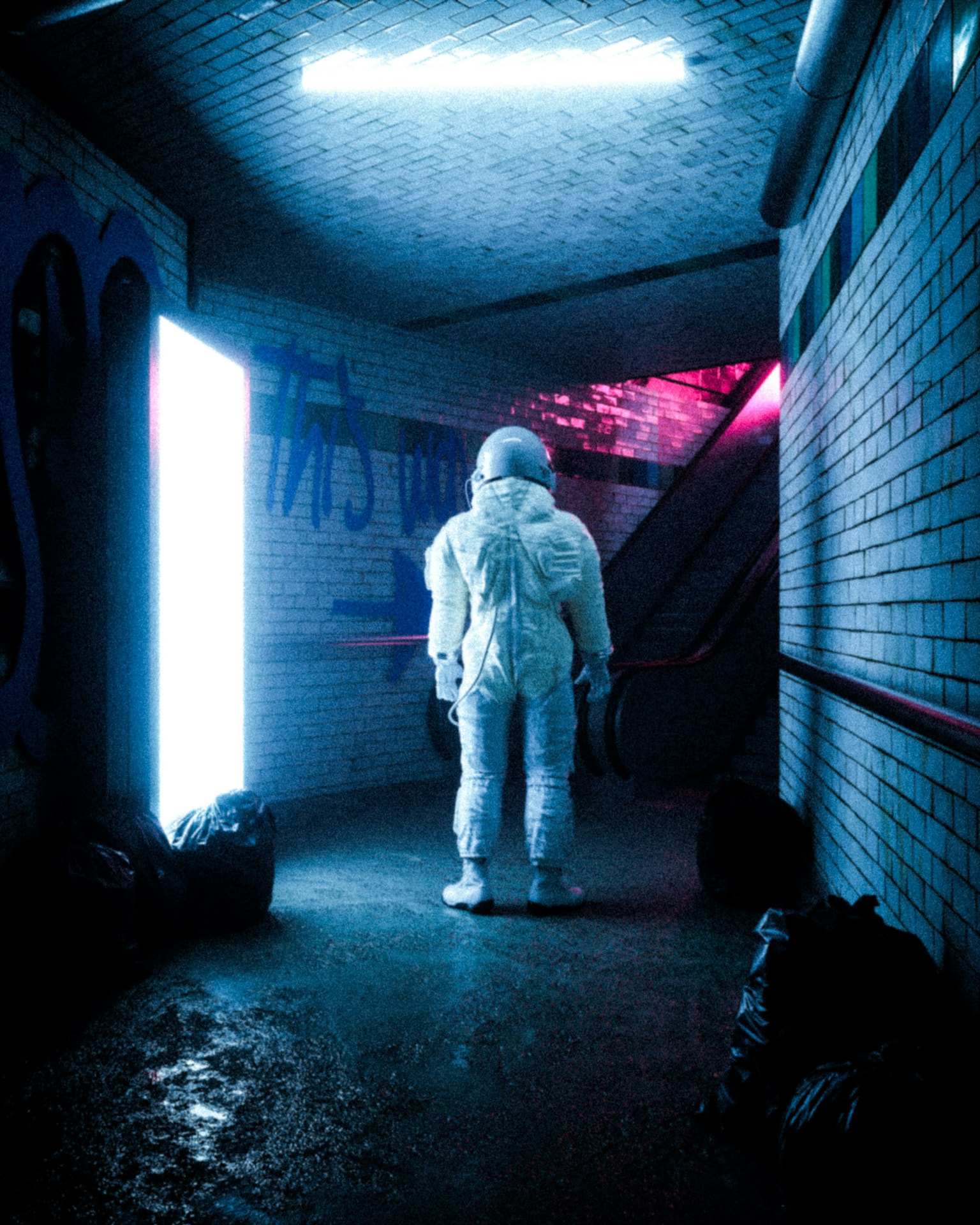Figure standing in a neon-lit underpass